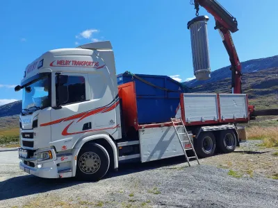 Kranbil løfter last i fjellet