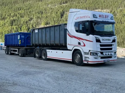 Lastebil med containere i fjellandskap