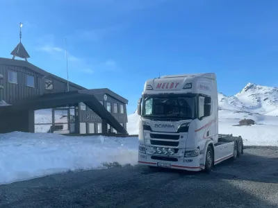 Melby-lastebil ved fjellhytte i snølandskap